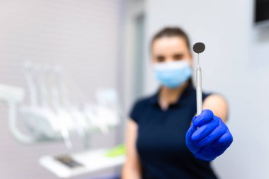 Diş hekimi kameradaki ağız boşluğunu incelemek için ayna gösteriyor. 