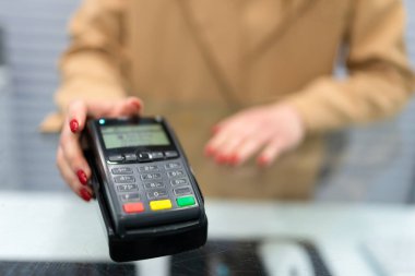 Kadın ödeme terminalini istemciye verir