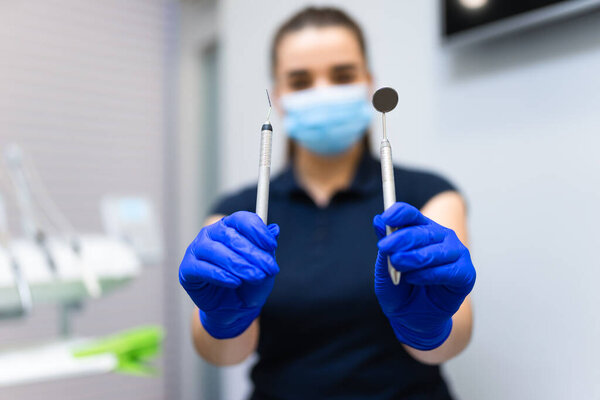 Dentist shows dental instruments into the camera