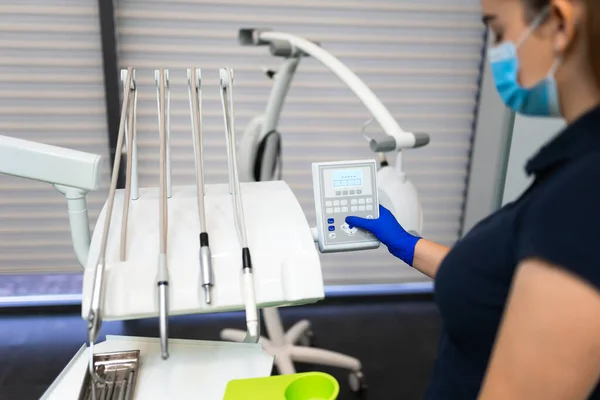 Dentist hand in glove press the control buttons of dental chair