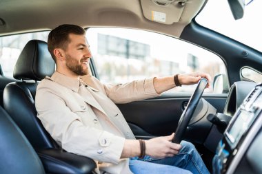 Araba kullanan kendine güvenen yakışıklı bir adam.