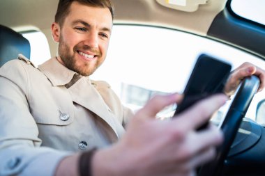 Arabadaki yakışıklı adam, akıllı telefona bak.