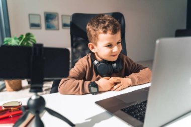 Çocuk internetten bilgisayar okuyor.