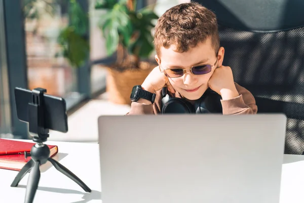 Schoolboy watches online video lessons on laptop. Studying during an epidemic