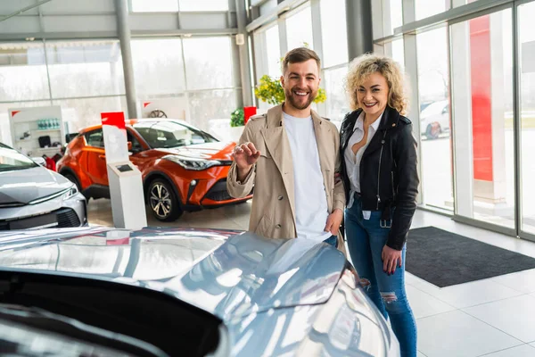 Beautiful couple in car dealership chooses car