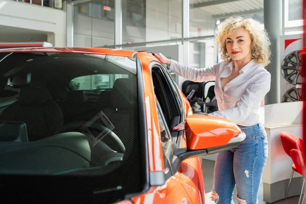 Curly Mulher Olha Carro Para Concessionária — Fotografia de Stock