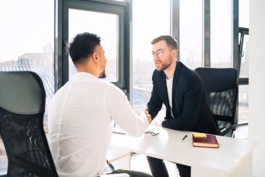 Ofisteki iki işadamı birbirini selamlıyor.