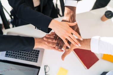 Çok ırklı iş adamları el ele tutuşuyor.