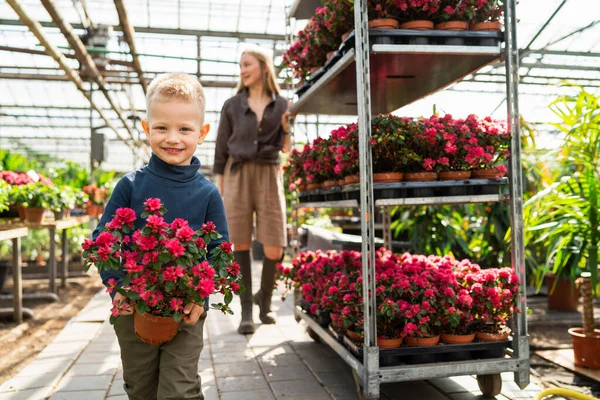 Pojke Med Krukväxt Och Hans Mamma Med Vagn Med Blommor — Stockfoto