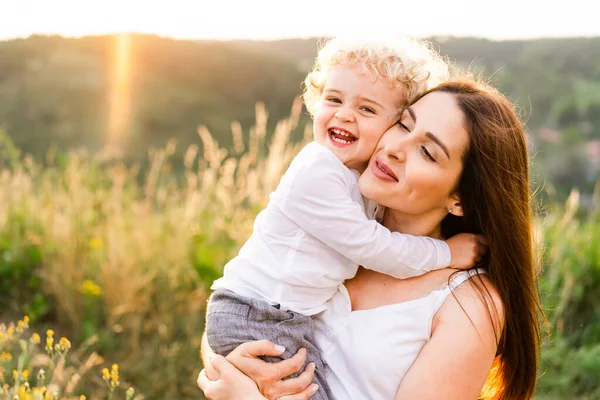 Glückliche Mutter Umarmt Ihren Sohn Bei Sonnenuntergang — Stockfoto