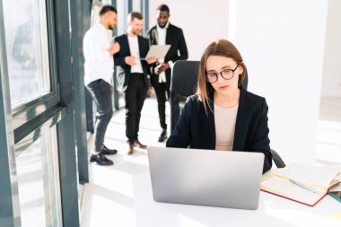 Sekreter dizüstü bilgisayarın ofisinde çalışıyor.