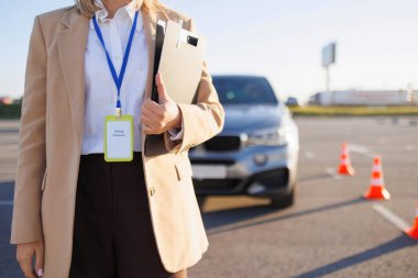 Sürücü Eğitmeni Araba Yakınındaki Eğitim Alanında Not Defteri