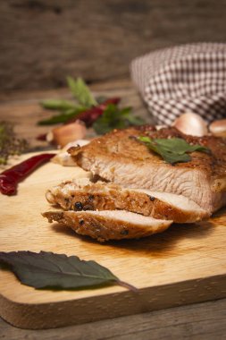 Kesme tahtasında domuz rostosu. Eski ahşap masada.