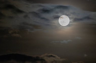 Dolunay ya da arka planda bulanık bulutlarda parlayan ışık evresi