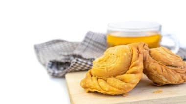 Tahta kesme tahtasında beyaz arka planda körili puf böreği.