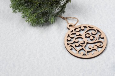 Yeni yıl dekorlu Noel kartı. Tahta kar taneleri ve toplar arka planda. Tahta oyuncaklar ve ardıç dalları.