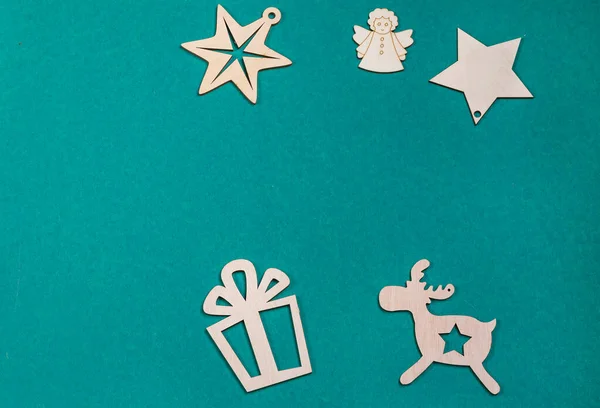 Christmas card with stars,angel and deer with gift box.Wooden Christmas toys on a colored background.