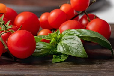 # Yeşil fesleğen ve kiraz domatesleri # # Koyu bir tahta üzerinde yakın plan #.