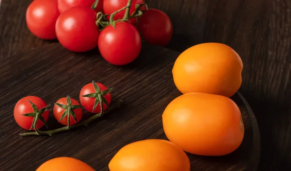 Três Tomates Cereja Ramo Entre Grandes Tomates Amarelos Vermelhos Conceito — Fotografia de Stock
