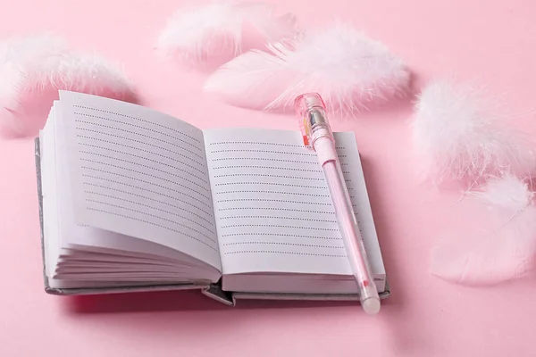 Pembe arka planda bir kalemle birlikte açık bir defter. Romantik ruh hali kavramı