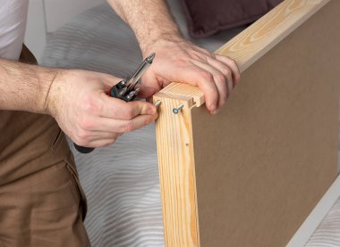 Adam evde beyaz tuvalet masası topluyor. Mobilya montaj konsepti