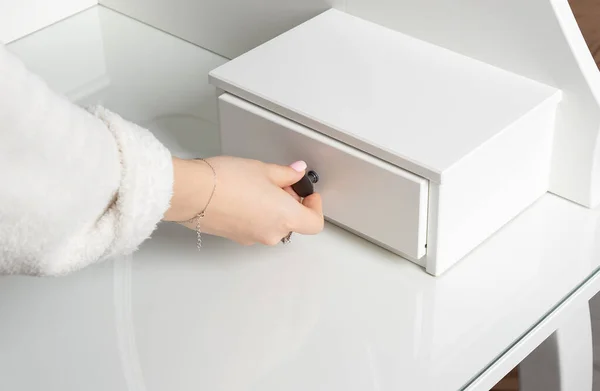 Kız tuvalet masasının çekmecesini açar ve kapatır..