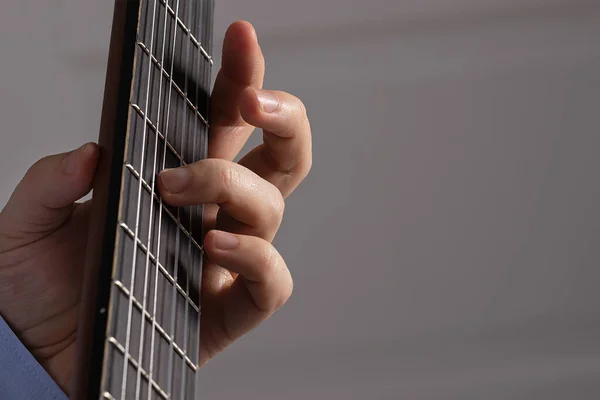 Adam gitar akorları gösteriyor. Gitarı yakın plan çalıyorum.