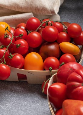 Masadaki sepetin içinde kırmızı ve sarı domatesler. Sebze topla.