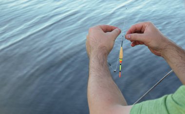 Elinde balık yemi ve olta tutan bir adam. Hobi ve eğlence kavramı..