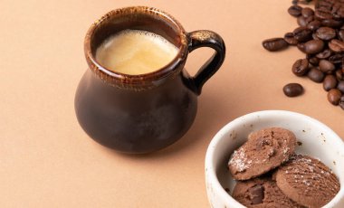 coffee in dark cup on the background of coffee beans and cookies. Morning ritual concept