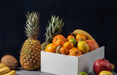 Arka planda tropikal meyveler olan meyve sepeti. Vitamin meyve seti