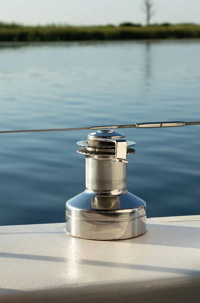 mooring bollard on small yacht close-up. Metal reel for rope against background of water surface
