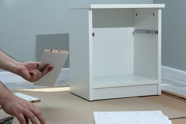 Yatağın başucundaki masanın sahibine göre montajı. Yeni mobilya konsepti ve teslimatı. Yeni beyaz mobilyalar alıyorum.