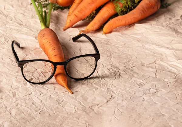Taze havuç giymiş gözlük. Taze sebzeli A vitamini. Arka planda taze havuç.