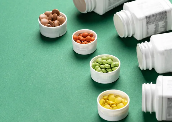 Four Types Pills Plastic Jars Green Background Colored Vitamins Healthy — Stock Photo, Image