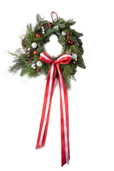 Beyaz toplu Noel çelengi, beyaz arka planda kırmızı kurdeleli dekoratif donmuş böğürtlenler.