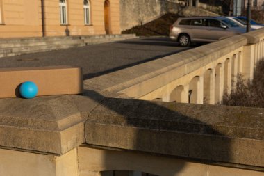 Mavi top ve karton kutu taşın üzerinde güneşli şehir ortamında