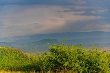 Yeşil çimenli ve mavi gökyüzü olan dağ manzarası