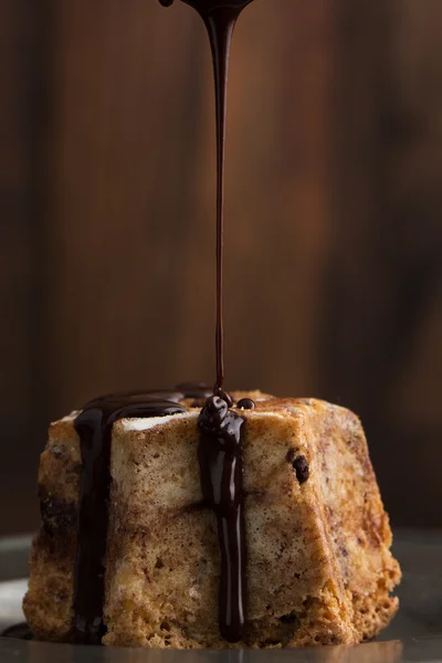 Close-up of cake with dark chocolate pouring — Stock Photo, Image