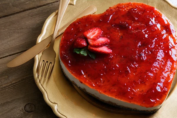 Heart shaped cheesecake with raspberry jelly on a gold plate — Stock Photo, Image