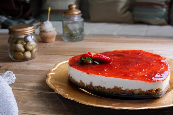 Pastel de queso en forma de corazón con gelatina de frambuesa en una placa de oro — Foto de Stock