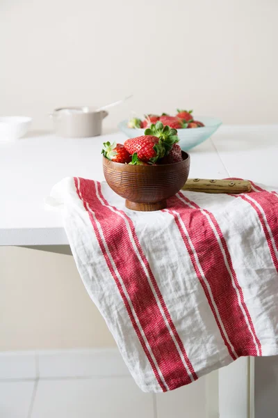 Fresas en tazón de madera sobre toalla de cocina, rayas rojas y blancas — Foto de Stock