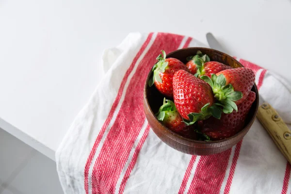 Strawberries in wooden bowl on dishtowel, red and white stripes — Stock Photo, Image