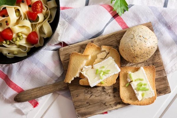 Pão torrado, com queijo brie e cebolinha e tagliatelle com — Fotografia de Stock