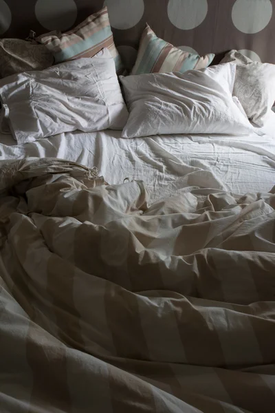 Cama de casal não feita, com a luz da manhã — Fotografia de Stock