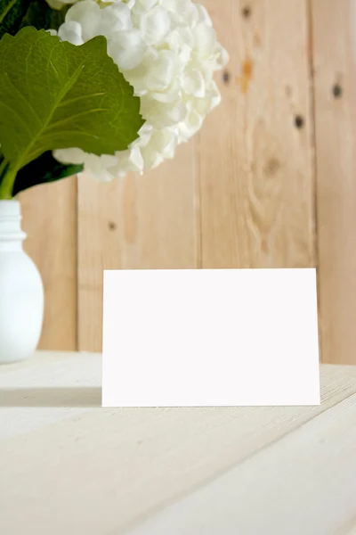 Blanck tarjeta de visita, caja de regalo y flores, sobre fondo a rayas — Foto de Stock