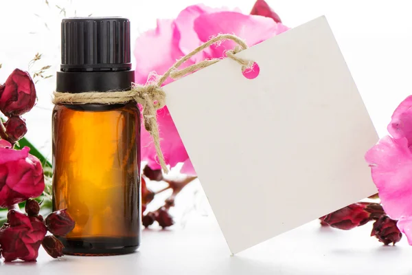 Essential oil, empty tags and roses flowers — Stock Photo, Image