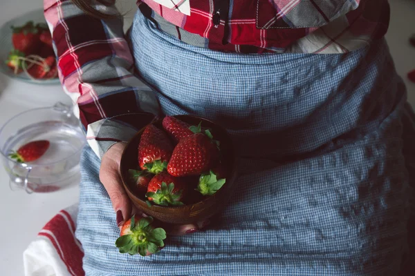 Kvinna sitter med skål med jordgubbar i hand. — Stockfoto