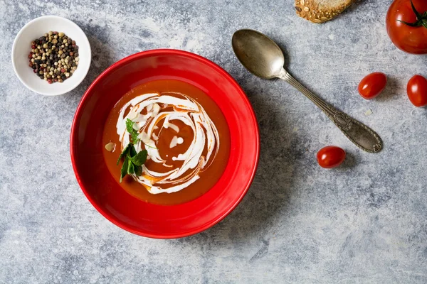 Sopa de crema de tomate en lazo rojo, fondo grunge —  Fotos de Stock