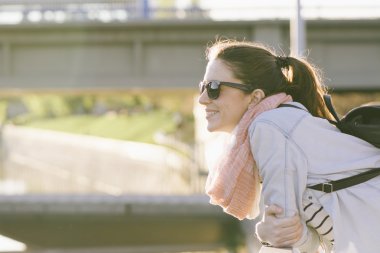 Bununla birlikte güneş gözlüklü, köprüye yaslanmış güzel gülümseyen kadın